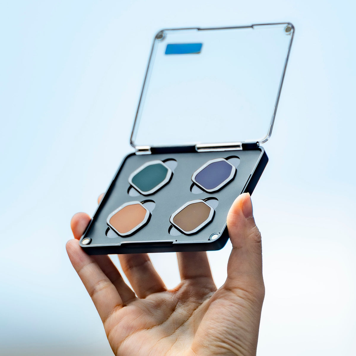 A hand holds an open, four-slot Tilta filter case containing specialized ND filters for Insta360 Luna Pro camera