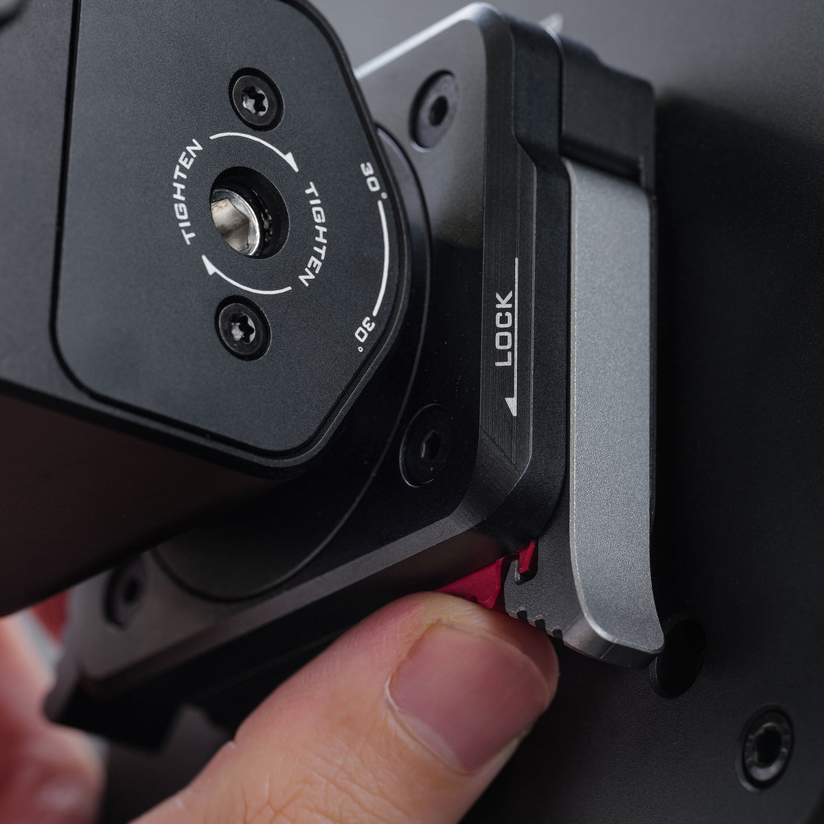 Close-up of a mounting bracket with a locking lever and a rotation dial marked with 